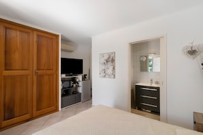 A bedroom with a large wardrobe, a flat-screen TV, a microwave, and a sink. - Bed and Breakfast "L'isula" with Mountain View, Wi-Fi, and Air Conditioning (Porto-Vecchio)