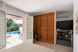 A room with a pool view, a TV, and a wardrobe. - Bed and Breakfast "L'isula" with Mountain View, Wi-Fi, and Air Conditioning (Porto-Vecchio)