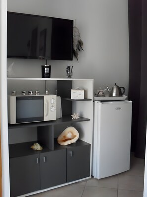 A compact kitchen with a microwave, toaster, and refrigerator.