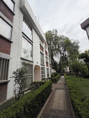 A building with a brick facade, large windows, and a gated entrance. - Vrbo Property (Ciudad de México)