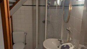 Ein kleines Badezimmer mit Toilette, Waschbecken und Dusche.