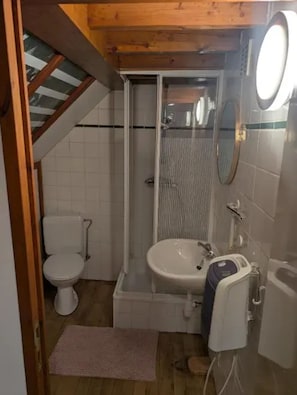A small bathroom with a toilet, sink, and shower. - Homerez - Studio Hamois (Hamois)