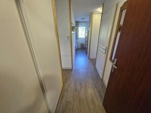 A narrow hallway with wooden flooring leading to a door at the end. - Apartment with balcony and heated indoor swimming pool (Saint-Sorlin-d´Arves)