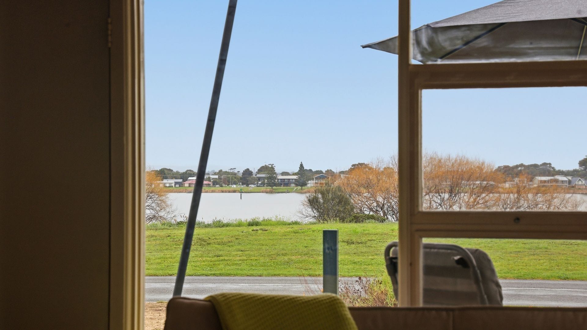 A room with a window overlooking a body of water and a grassy area.