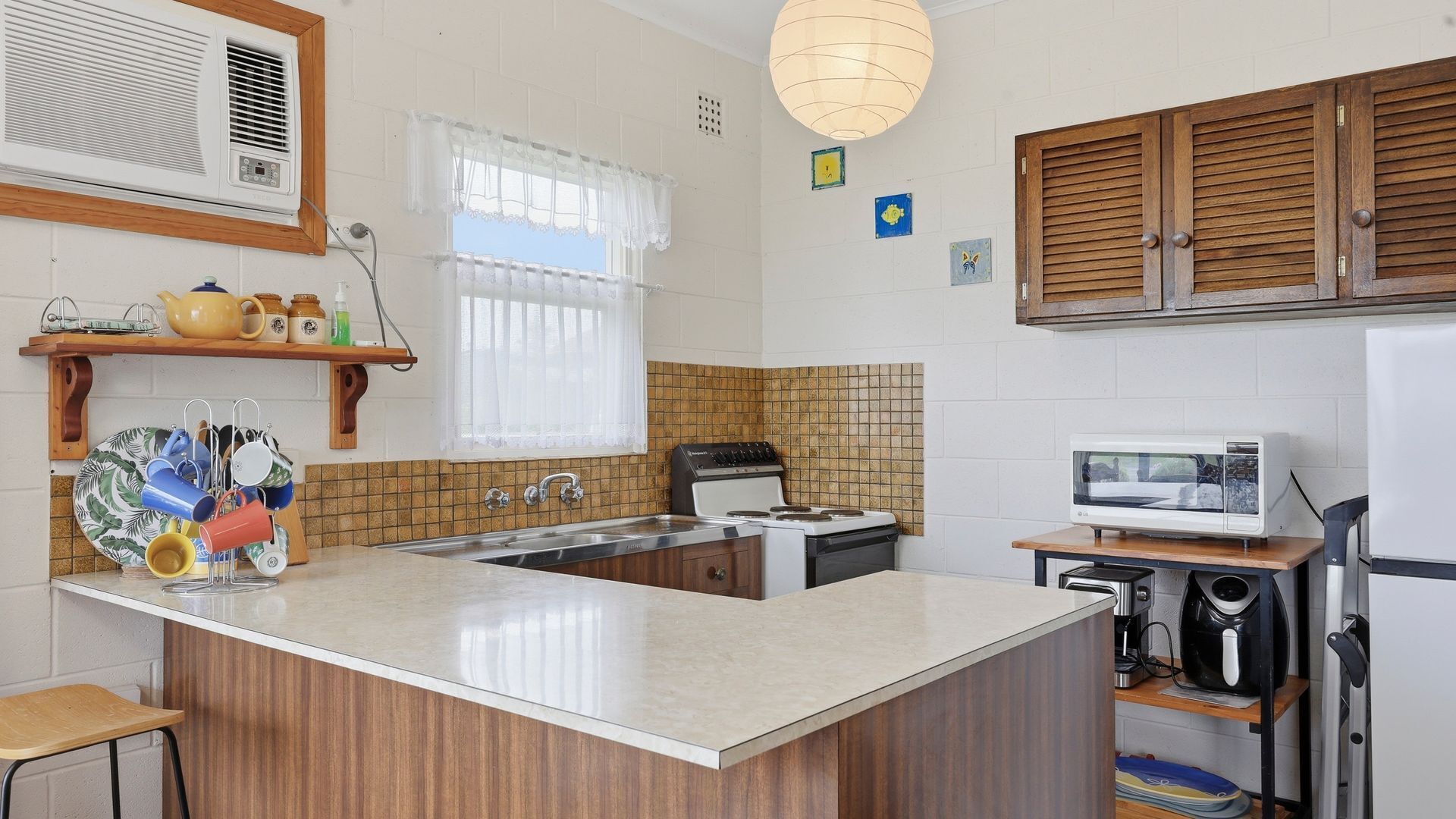 A kitchen with a central island, a stove, a microwave, and a sink.