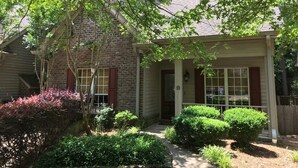A brick house with a porch, a small garden, and a tree. - Hidden Gem! 106 Windstone (Oxford)