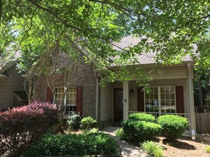 A brick house with a porch, a small garden, and a tree. - Hidden Gem! 106 Windstone (Oxford)