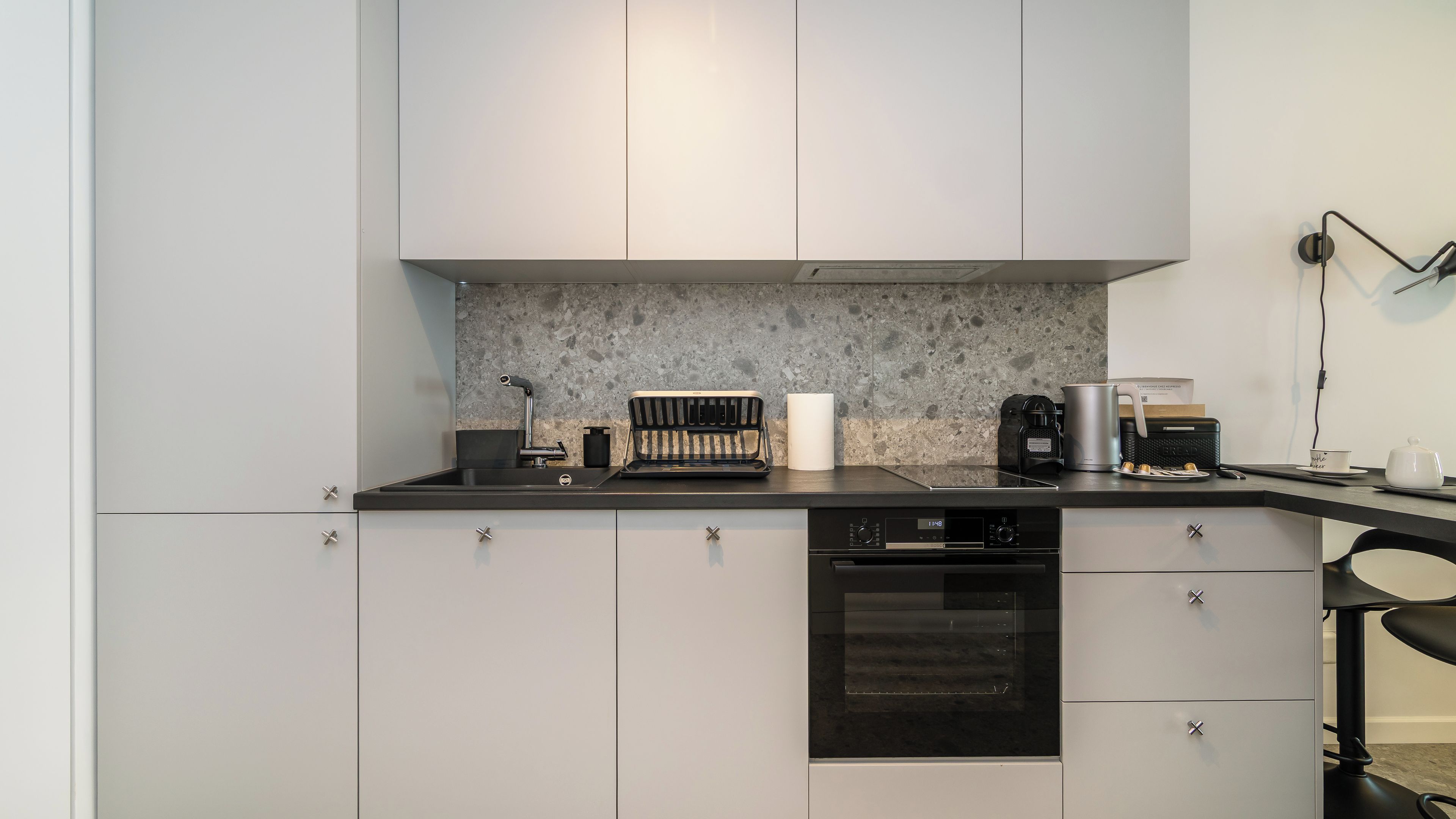 A modern kitchen with a built-in oven, a coffee maker, and a bread toaster on the countertop.