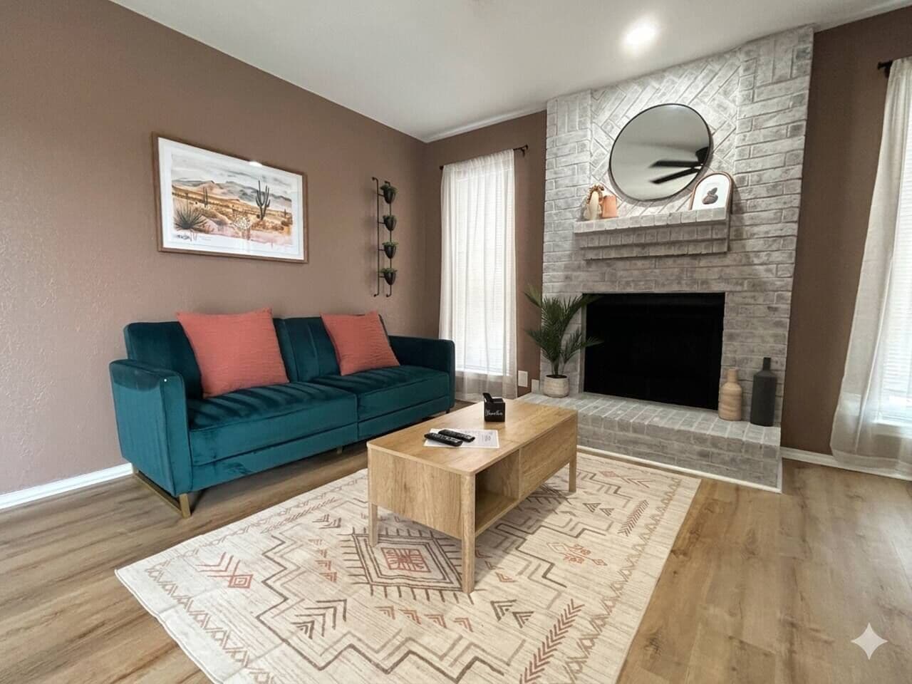 Un salon avec un canapé, une table basse, une cheminée et un tableau encadré au mur.