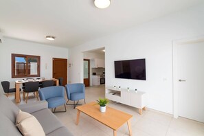 A modern living room with a sofa, chairs, a coffee table, and a TV. - Villa Naira by Villa Plus (Playa Blanca)