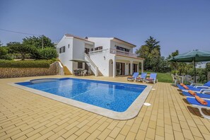 A swimming pool with lounge chairs and a staircase leading to a building. - Villa Casa Mafalda by Villa Plus (Carvoeiro)