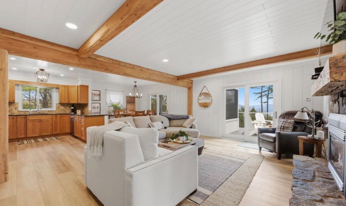 A spacious living area with a fireplace, a dining area, and a kitchen with wooden cabinets.