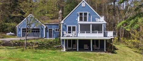 A two-story blue house with a covered porch and a garage.