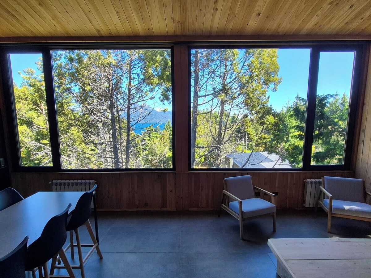 A room with a large window, a table, and two chairs.