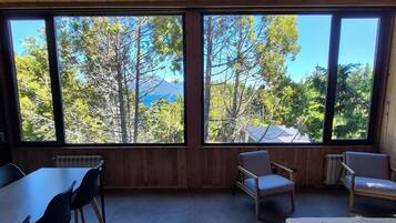 A room with a large window, a table, and two chairs.