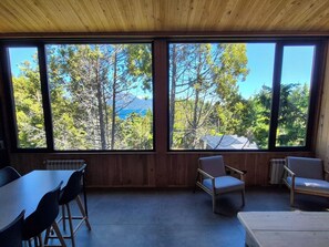 A room with a large window, a table, and two chairs.
