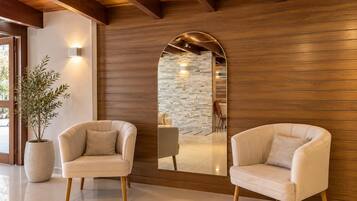 Un intérieur moderne avec deux fauteuils en cuir, un grand miroir et une plante en pot.