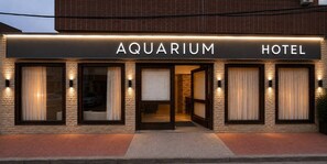 Exterior del Hotel Aquarium con un diseño moderno, que cuenta con amplias ventanas y una entrada destacada.