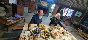 Een landelijke eethoek met houten meubels en diverse gerechten op een tafel.