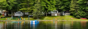 A lakeside property with cabins, a playground, and picnic tables.