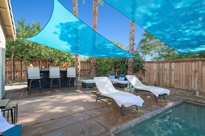 An outdoor pool area with lounge chairs, a barbecue setup, and a shaded canopy. - Early Check-In. AC Comfort + Pool, Spa +FAST WIFI (Coachella)