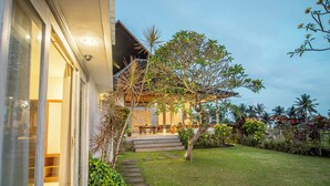 A modern house with a covered porch, a well-maintained lawn, and a variety of plants. - Kayun Retreat Mas Suite (Mas)