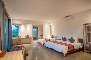Een moderne hotelkamer met twee bedden, een eettafel en uitzicht op het omliggende landschap.