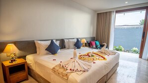 A hotel room with a large bed, a nightstand with a lamp, and a view of the sea through a sliding door. - Kayun Retreat Mas Suite (Mas)
