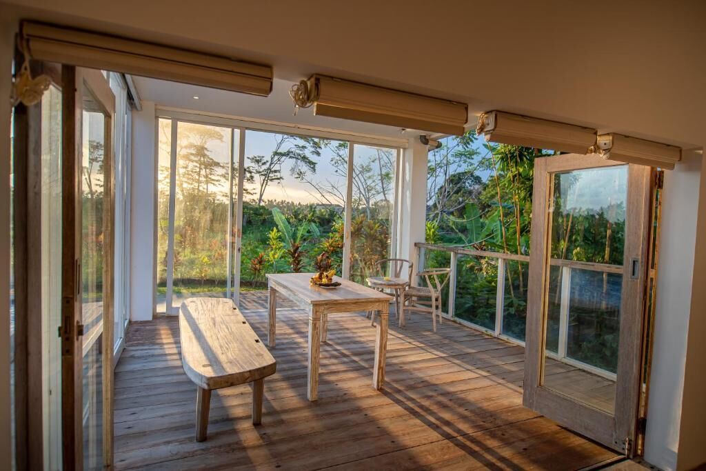 An open-plan living area with a wooden deck, a dining table, and chairs.