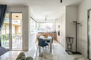 A modern apartment with a dining area, kitchen, and a balcony with outdoor furniture. - Oasi del Garda in Desenzano - Pool, Garden, and Garage (Desenzano del Garda)