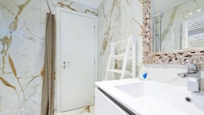 A bathroom with a white marble wall, a white sink, and a mirror with an ornate frame. - Oasi del Garda in Desenzano - Pool, Garden, and Garage (Desenzano del Garda)