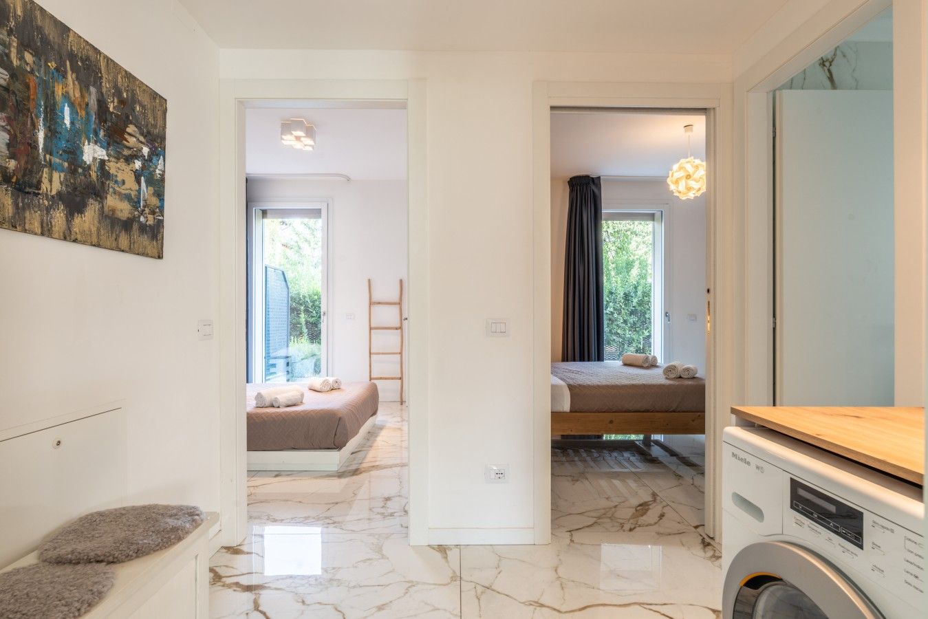 Ein Hotelzimmer mit Bett, Waschmaschine, einem Fenster mit Vorhängen und einem Bild an der Wand.