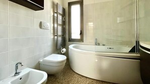A modern bathroom with a freestanding bathtub, a sink, and a toilet. - At Antico Molo Sea View: A cozy apartment near the beach. (San Cataldo)