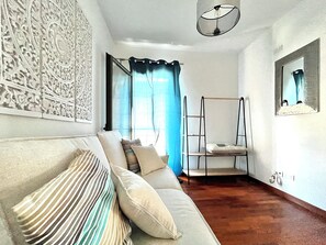 A room with a sofa, a ladder, a mirror, and a window with curtains. - At Antico Molo Sea View: A cozy apartment near the beach. (San Cataldo)
