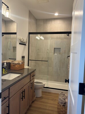 A modern bathroom with a shower, toilet, and vanity. - YOUR MT HOOD GATEWAY STARTS HERE! NEW 3 BD 2.5 BA HOME W/SMALL TOWN CONVENIENCE! (Sandy)