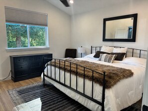 A bedroom with a bed, a dresser, a window, and a mirror. - YOUR MT HOOD GATEWAY STARTS HERE! NEW 3 BD 2.5 BA HOME W/SMALL TOWN CONVENIENCE! (Sandy)
