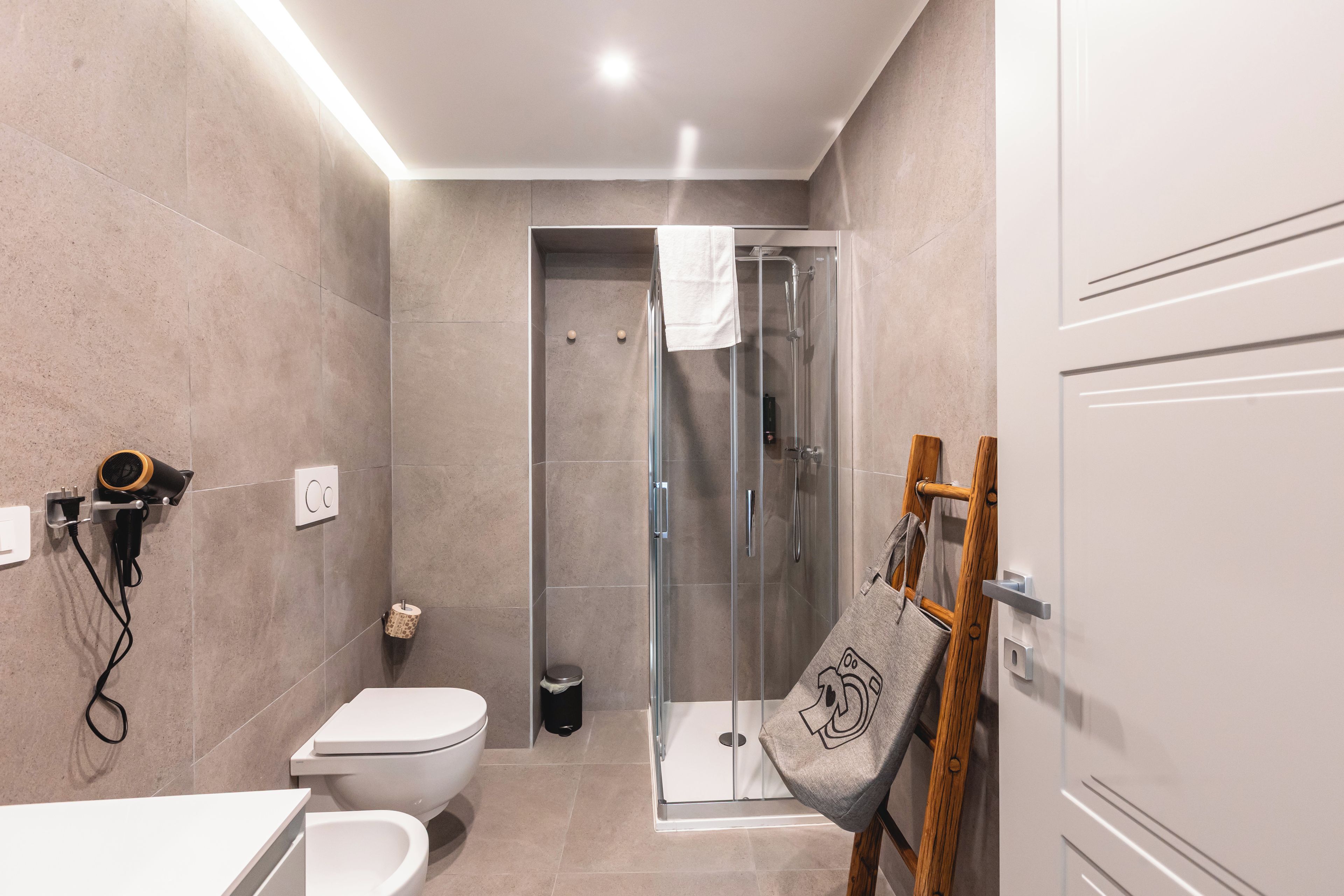Un bagno moderno con WC, bidet e cabina doccia in vetro.