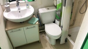 A bathroom with a sink, toilet, and shower curtain. - Quiet Studio in Lamalou – 10 min from Thermal Baths – Wi-Fi – Pets Welcome (Lamalou-les-Bains)