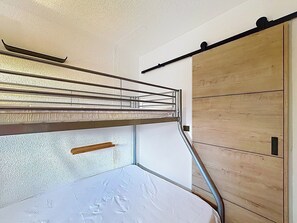 Una cama litera con barandillas de metal y cabecera de madera.