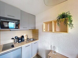 A modern kitchen with a microwave, sink, and wooden cabinets. - La Plagne Montalbert, ski-in/ski-out, in the heart of the resort, unobstructed view, ski lift. (Aime-la-Plagne)