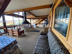 A cozy interior with a wooden bench, a cushioned seating area, and a staircase leading to an upper level. - Winterplace condo lodge - Ski in Ski out (Raleigh County)