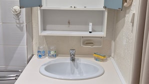 A bathroom with a white sink, wooden cabinets, a mirror, and a towel rack. - Apartment 'Le Lioran Font D'alagnon' with Mountain View (Laveissière)