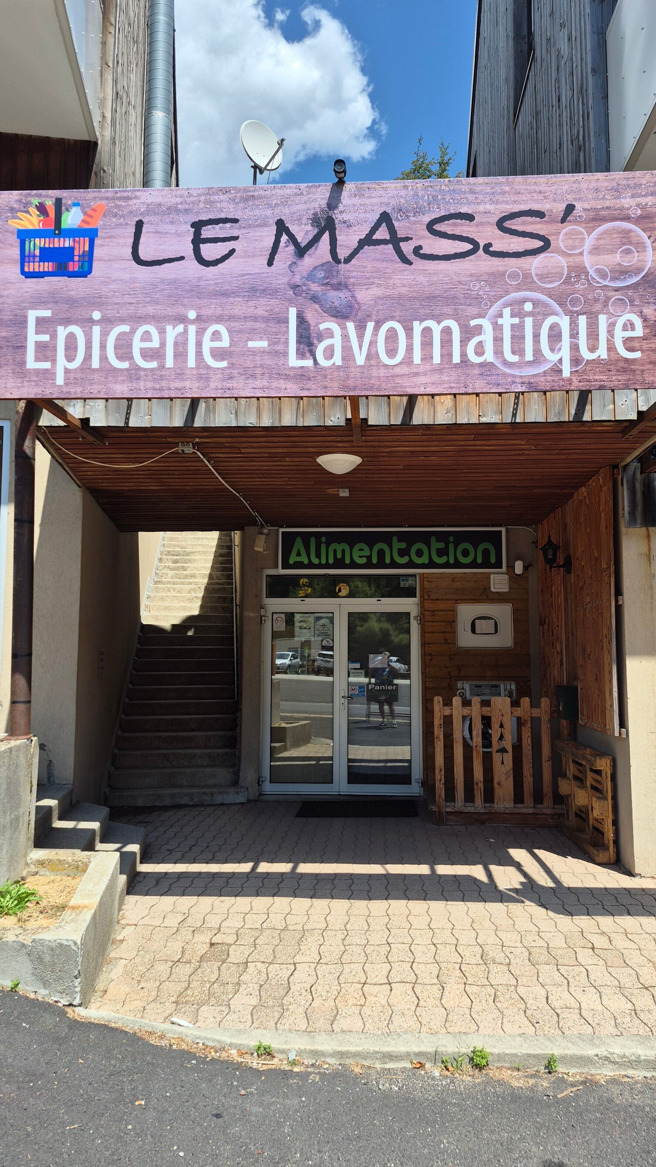 A storefront with a sign reading 'LE MASS' and 'Epicerie - Lavomatique'.
