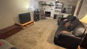 A living room with a fireplace, a television, and a sofa.