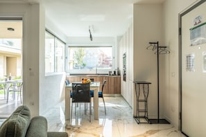 Een moderne keuken met een eethoek, grote ramen en uitzicht.