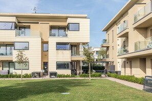 A modern apartment complex with multiple balconies, a covered outdoor seating area, and a well-maintained lawn. - Oasi del Garda in Desenzano - Pool&Garden&Garage (Desenzano del Garda)