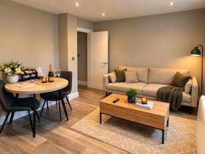 Ein modernes Wohnzimmer mit einem runden Esstisch, einer Couch und einem Couchtisch.
