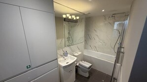 Ein modernes Badezimmer mit Duschkabine aus Glas, einem weißen Waschbecken und einer Toilette.