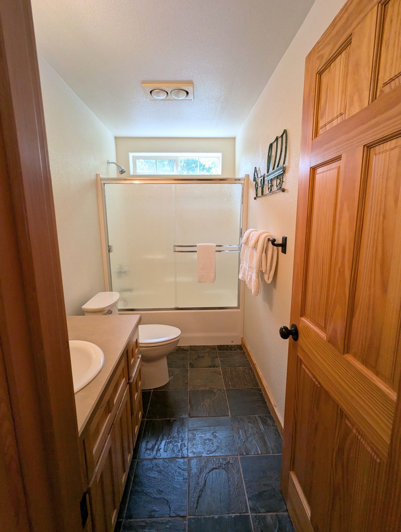 Een badkamer met douche, toilet en wastafel.