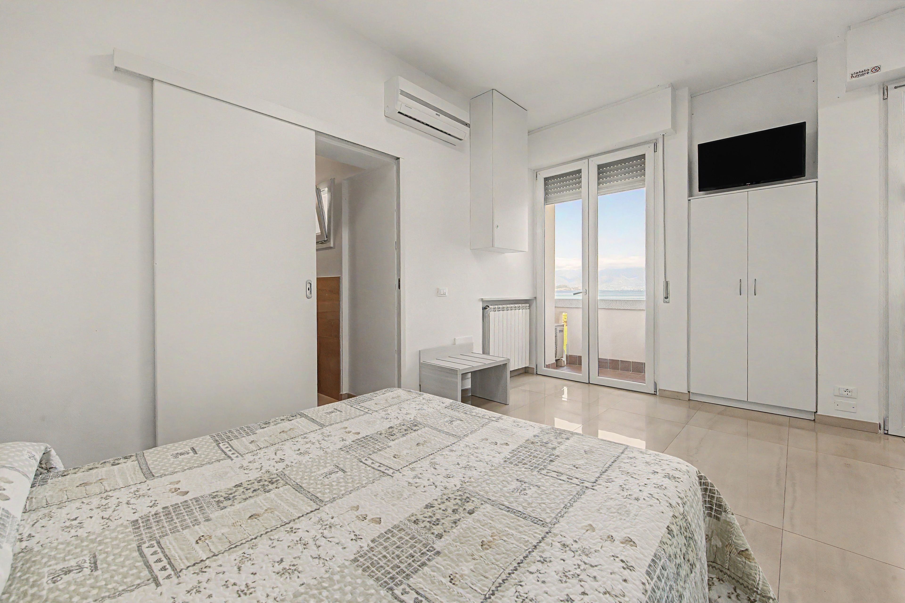 Una camera da letto con un letto, un armadio e vista sul mare.